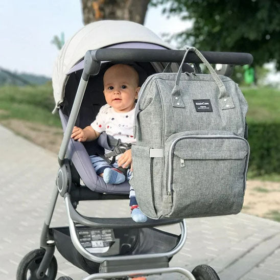 bebe dans sa poussette avec sac a dos a langer accroche