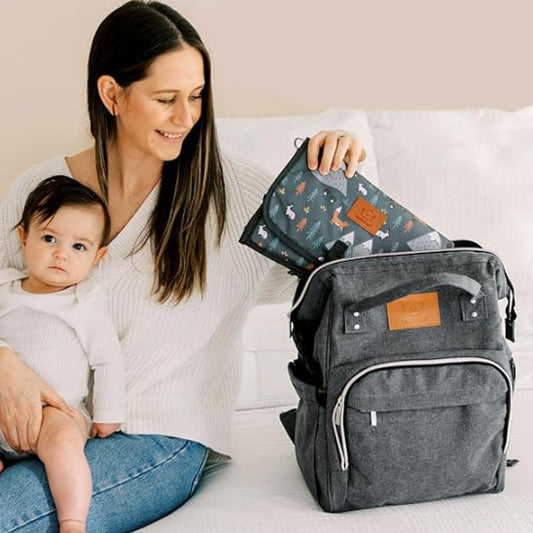 maman et fillette sur le lit utilisant le sac a dos a langer